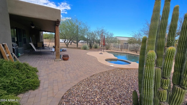 view of swimming pool with an in ground hot tub, a patio, and ceiling fan