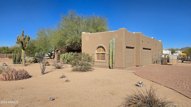 2926 W Tanya Trl, Phoenix, AZ 85086 - pueblo-style home featuring a garage, decorative driveway, stucco siding, and a gate