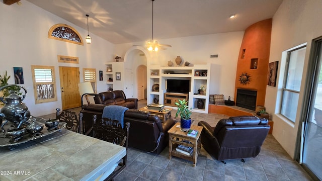 tiled living room featuring a large fireplace and high vaulted ceiling