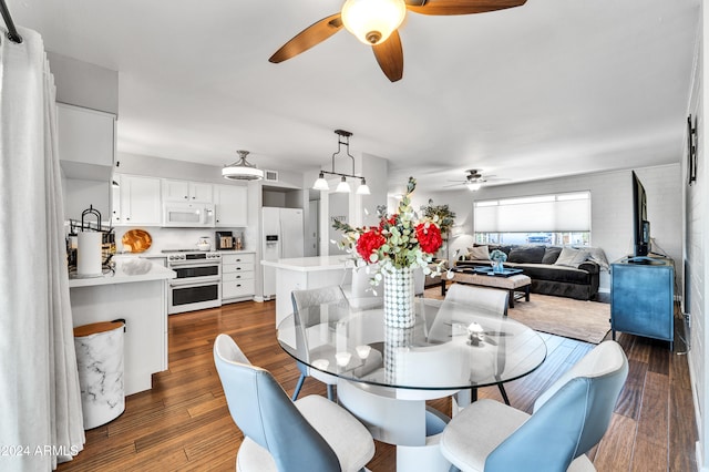 dining space with ceiling fan and dark wood-type flooring