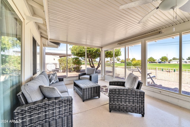 sunroom / solarium featuring a healthy amount of sunlight and ceiling fan