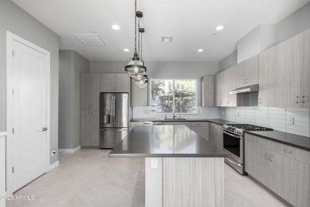 kitchen featuring sink, stainless steel appliances, backsplash, pendant lighting, and a kitchen island