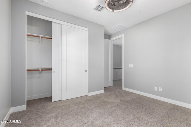 unfurnished bedroom with a closet and light colored carpet