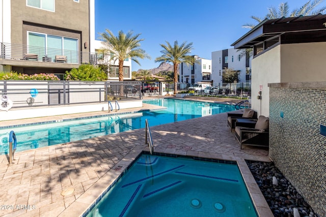 view of pool featuring a patio area and a hot tub