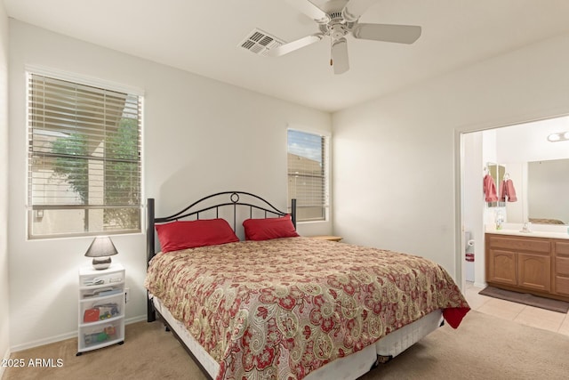 bedroom with light carpet, ensuite bath, visible vents, and ceiling fan