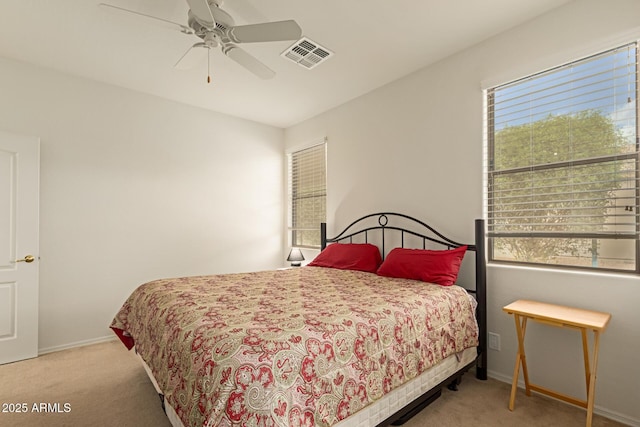 carpeted bedroom featuring baseboards, visible vents, and a ceiling fan