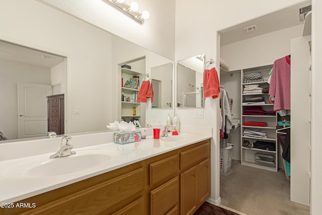 full bathroom featuring double vanity, a spacious closet, a sink, and visible vents