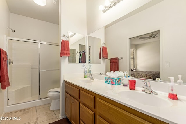 full bath with double vanity, a stall shower, toilet, tile patterned floors, and a sink