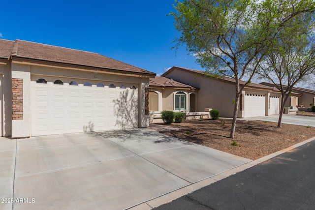 view of front of home with a garage, stone siding, concrete driveway, and stucco siding