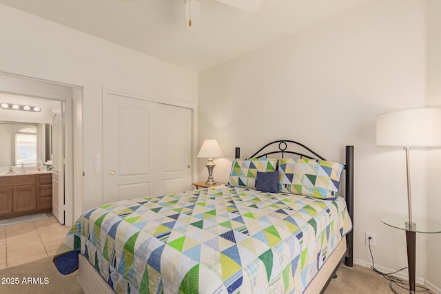 bedroom with a sink, light tile patterned floors, a ceiling fan, and a closet