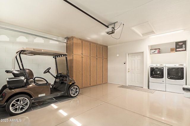 garage with independent washer and dryer, concrete block wall, and a garage door opener