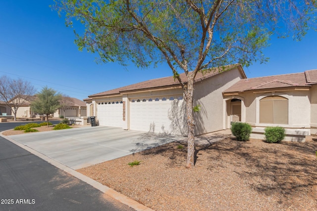 ranch-style home featuring a garage, concrete driveway, a tiled roof, and stucco siding