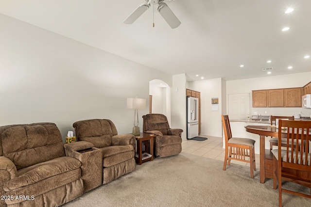 living area with a ceiling fan, arched walkways, light tile patterned floors, and recessed lighting