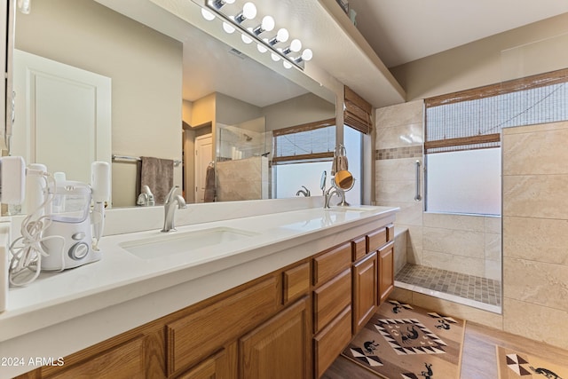 bathroom featuring a tile shower, vanity, and tile patterned floors