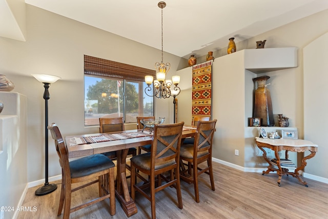 dining area with light hardwood / wood-style flooring and a notable chandelier