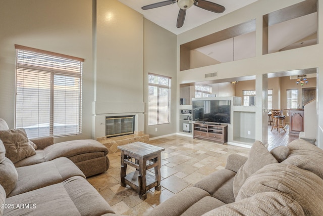 4864 E Eden Dr, Cave Creek, AZ 85331 - living area with high vaulted ceiling, ceiling fan, visible vents, a tile fireplace, and built in features
