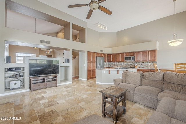 4864 E Eden Dr, Cave Creek, AZ 85331 - living room with a ceiling fan, stone finish floor, high vaulted ceiling, and visible vents