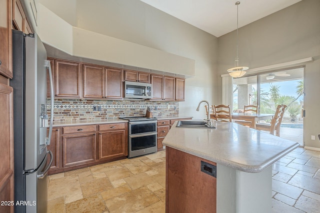 4864 E Eden Dr, Cave Creek, AZ 85331 - kitchen with brown cabinets, stainless steel appliances, a sink, a high ceiling, and stone tile floors