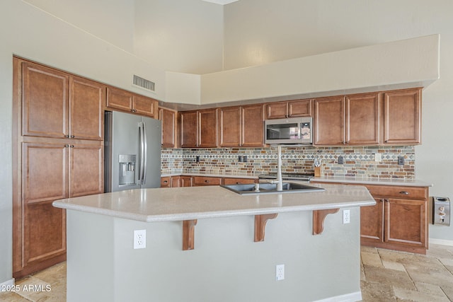 4864 E Eden Dr, Cave Creek, AZ 85331 - kitchen with a towering ceiling, light countertops, stainless steel appliances, visible vents, and decorative backsplash