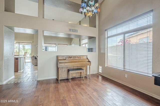 4864 E Eden Dr, Cave Creek, AZ 85331 - interior space with an inviting chandelier, baseboards, a towering ceiling, visible vents, and wood finished floors