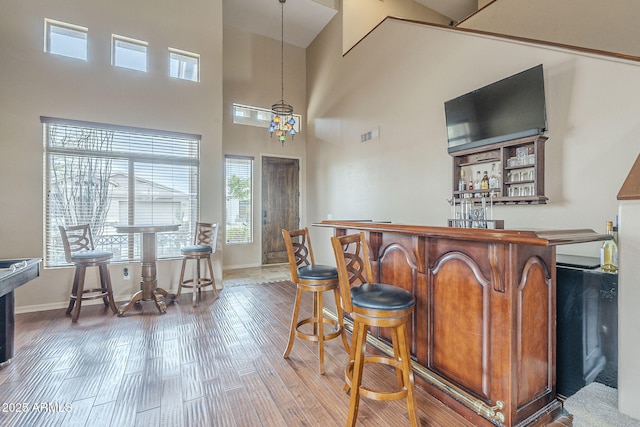 4864 E Eden Dr, Cave Creek, AZ 85331 - bar with a bar, a high ceiling, wood finished floors, baseboards, and decorative light fixtures
