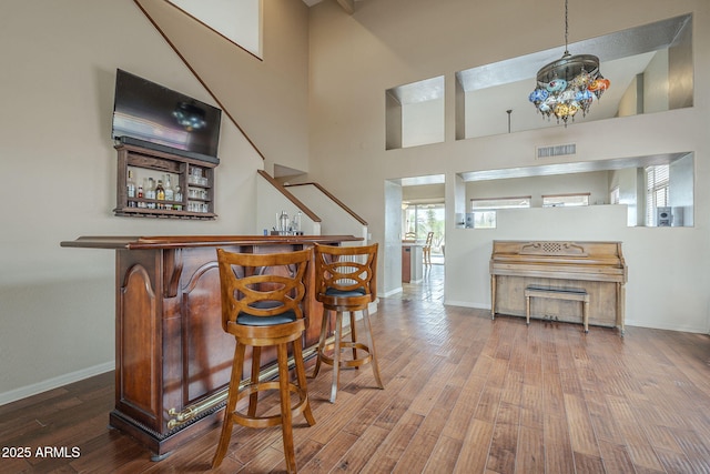 4864 E Eden Dr, Cave Creek, AZ 85331 - bar with a bar, baseboards, visible vents, and wood finished floors