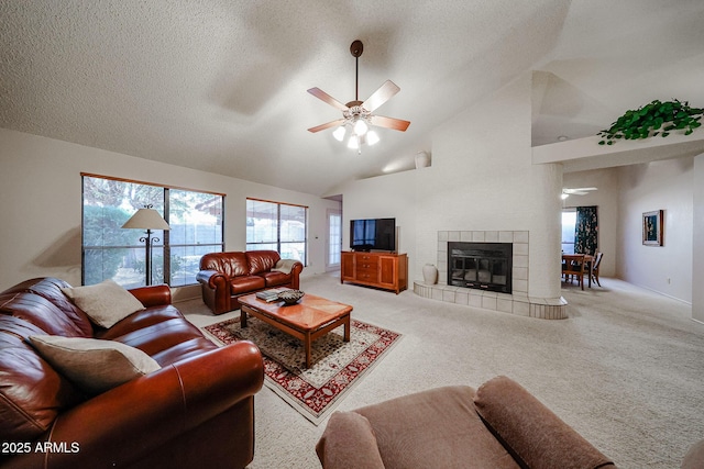 living area featuring a fireplace, a textured ceiling, a ceiling fan, and carpet floors