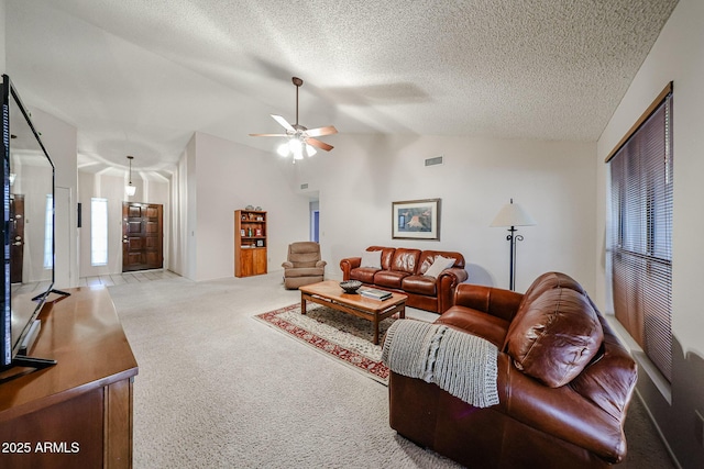 carpeted living area with visible vents, lofted ceiling, a textured ceiling, and a ceiling fan