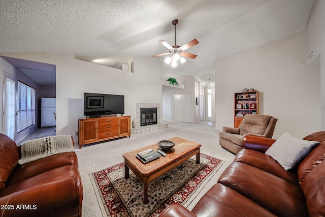 living area featuring light colored carpet, a fireplace, a textured ceiling, and vaulted ceiling