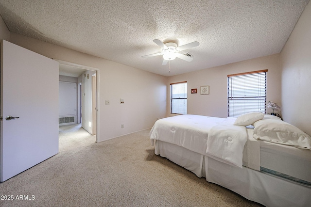 bedroom featuring visible vents, a ceiling fan, carpet flooring, and a textured ceiling