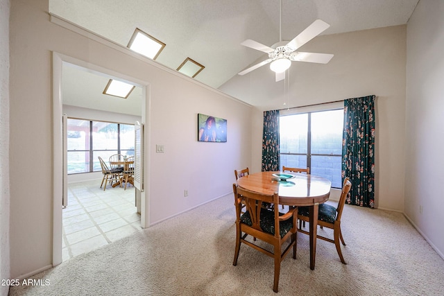 dining space with light carpet, a ceiling fan, and vaulted ceiling