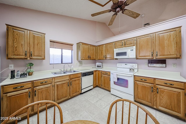 kitchen with light floors, white appliances, brown cabinets, and a sink