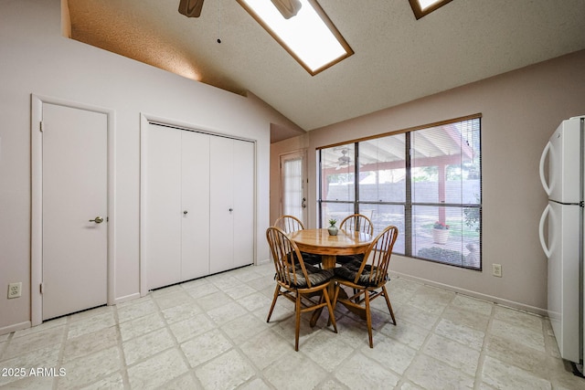 dining space featuring a ceiling fan, lofted ceiling, light floors, and a textured ceiling