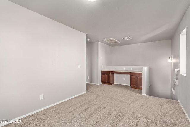 unfurnished bedroom with visible vents, built in study area, carpet, and baseboards
