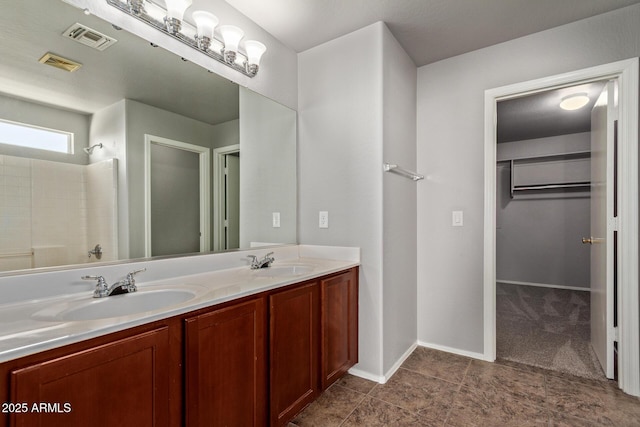 bathroom featuring a sink, a spacious closet, and visible vents