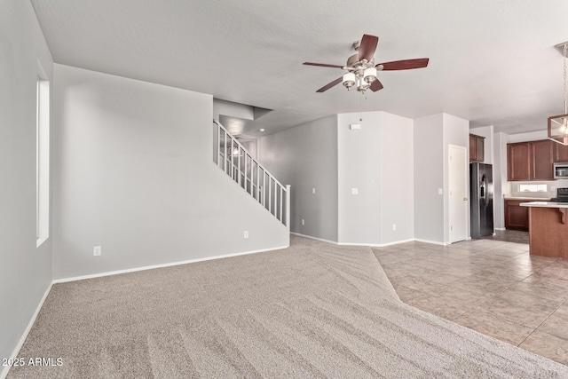 unfurnished living room featuring a ceiling fan, light carpet, and baseboards