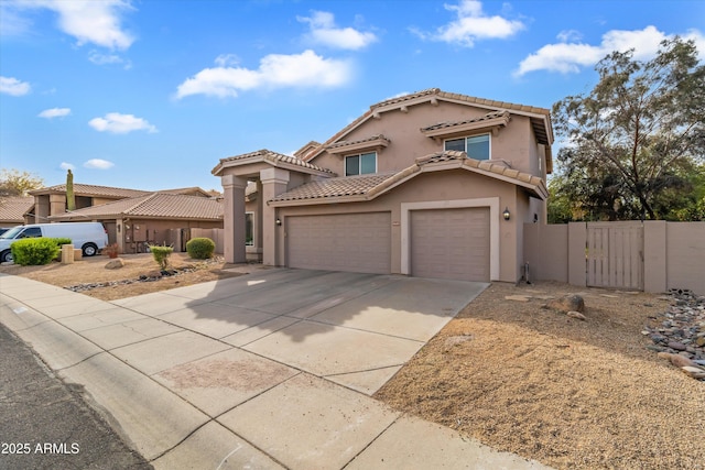 mediterranean / spanish-style house featuring a garage, fence, concrete driveway, a gate, and stucco siding