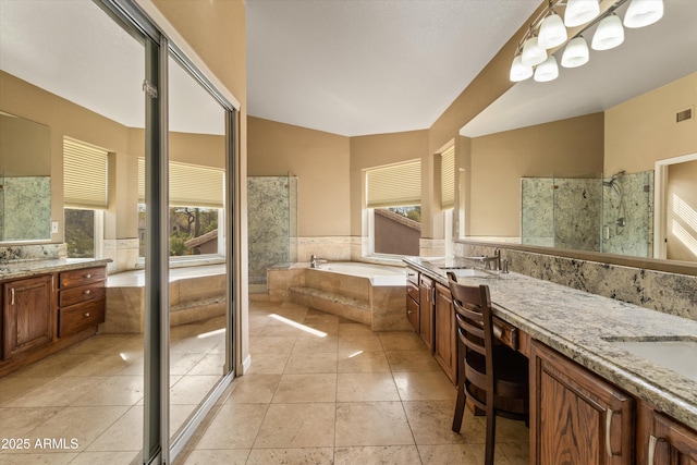 bathroom featuring a healthy amount of sunlight, a sink, a bath, and tile patterned floors