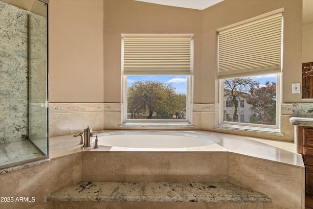 full bathroom featuring a garden tub and vanity