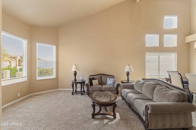 living area featuring high vaulted ceiling, carpet flooring, and baseboards