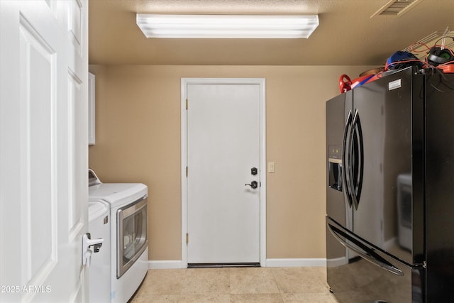 clothes washing area featuring laundry area, washing machine and clothes dryer, visible vents, and baseboards