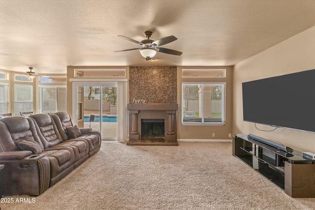 carpeted living room featuring a large fireplace, ceiling fan, a textured ceiling, and baseboards