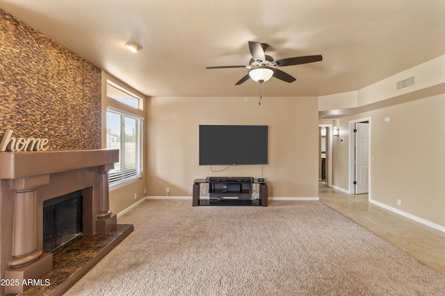 unfurnished living room featuring carpet, visible vents, a fireplace with raised hearth, ceiling fan, and baseboards