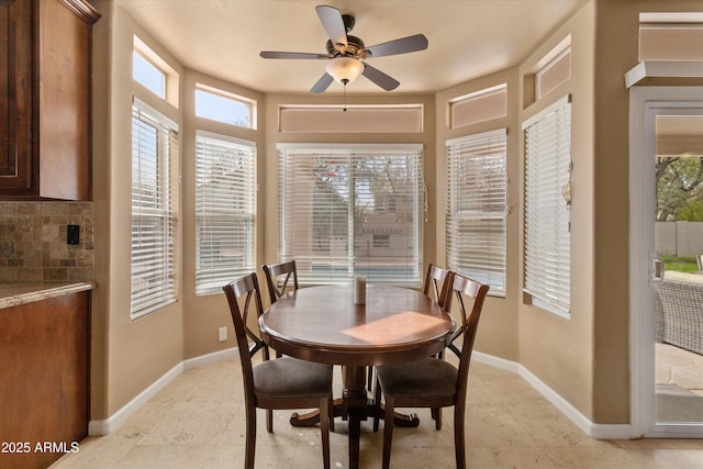 dining space featuring a ceiling fan and baseboards