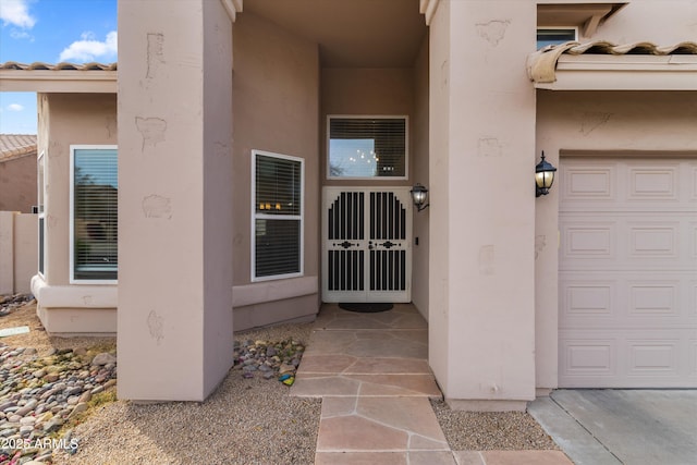 property entrance featuring a tiled roof and stucco siding