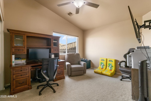 carpeted office space with baseboards, visible vents, vaulted ceiling, and a ceiling fan