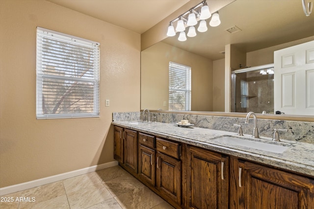 full bathroom with a stall shower, baseboards, visible vents, and a sink