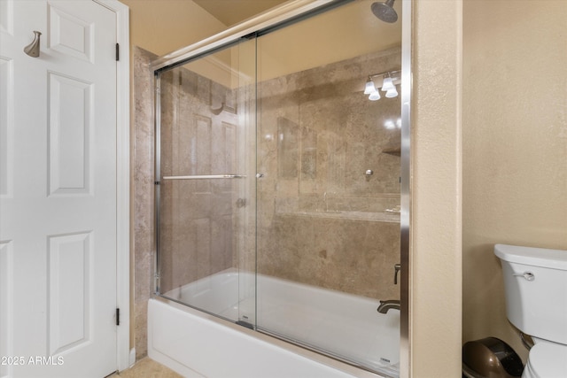 full bathroom with toilet and shower / bath combination with glass door