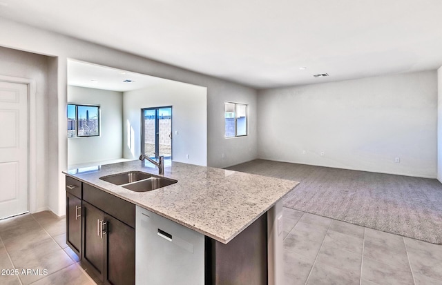 kitchen with stainless steel dishwasher, dark brown cabinetry, sink, and an island with sink