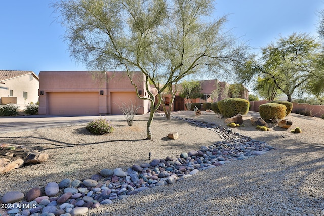 pueblo-style house featuring a garage